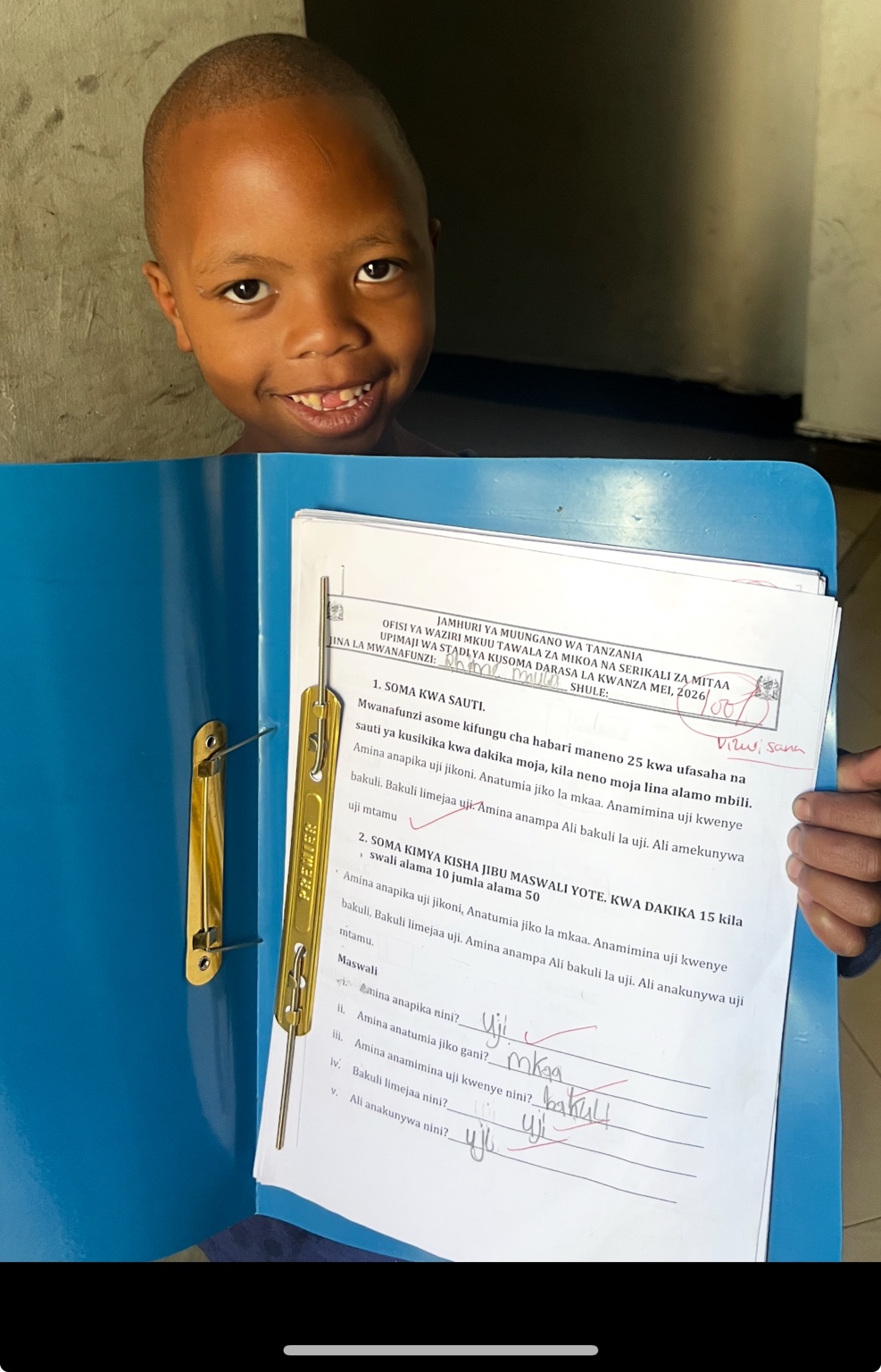 A child holding up a completed piece of schoolwork.