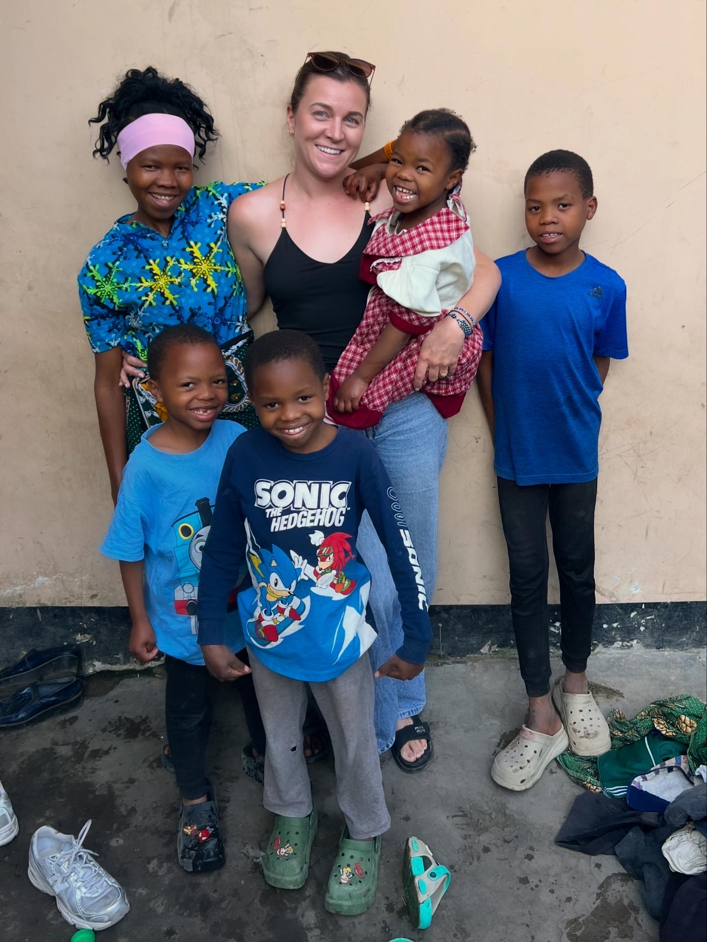 The children with a supporter outside their family's new home in Arusha.