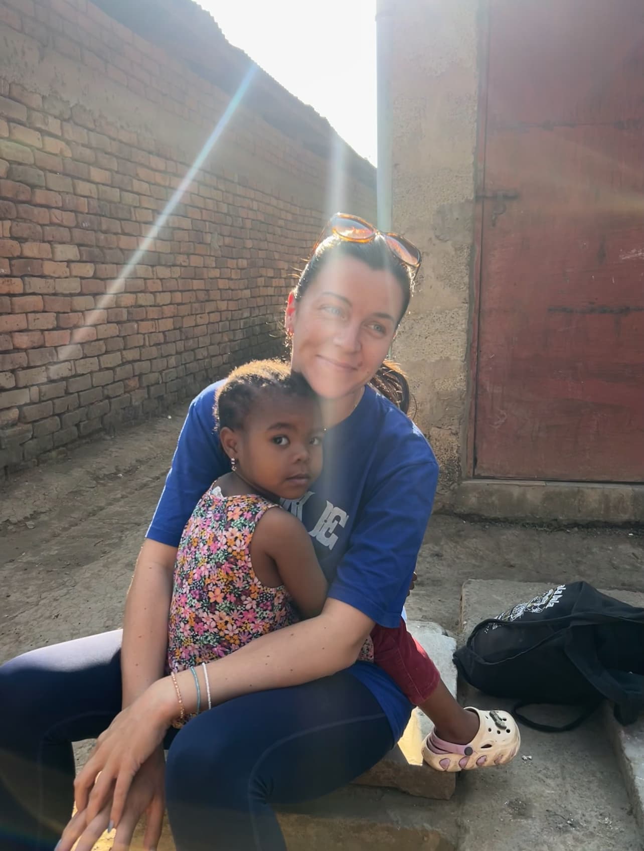 A child sitting closely with a supporter in Arusha.