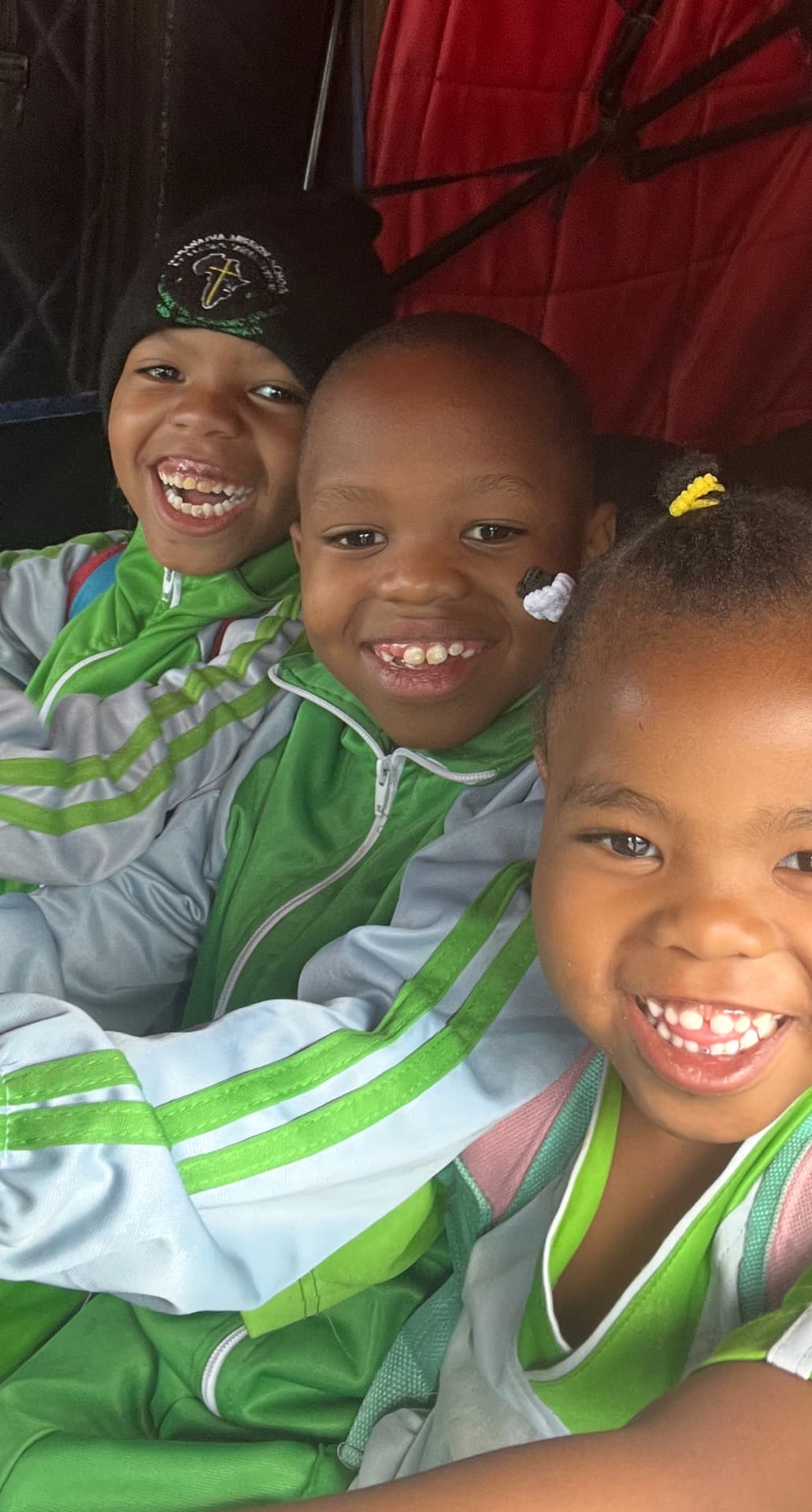 Issa, Rahim and Nurath laughing together in their sports kit at their new home.
