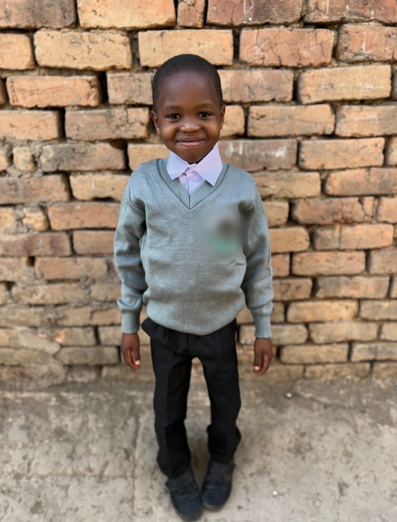 Issa smiling in his school uniform.