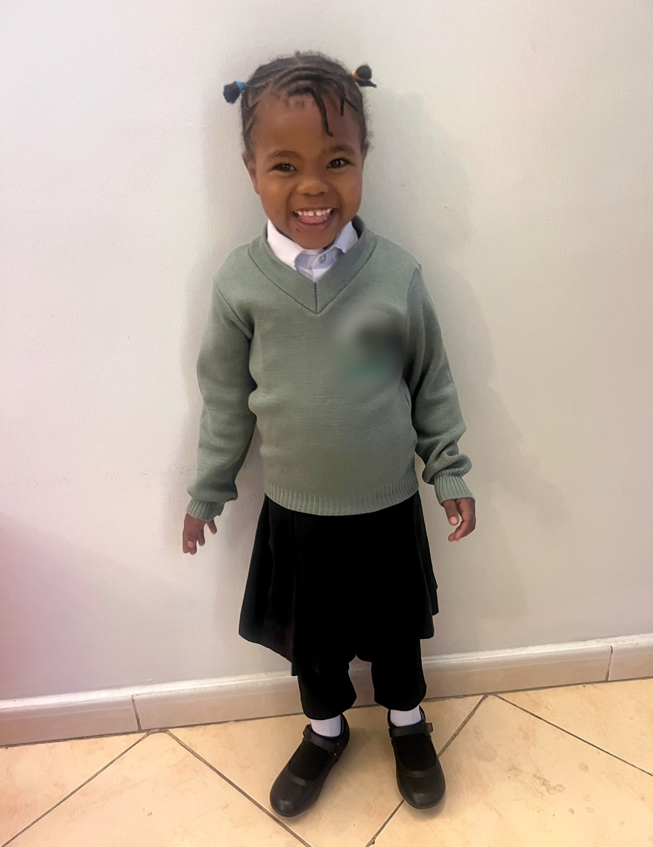 Nurath smiling in her school uniform.