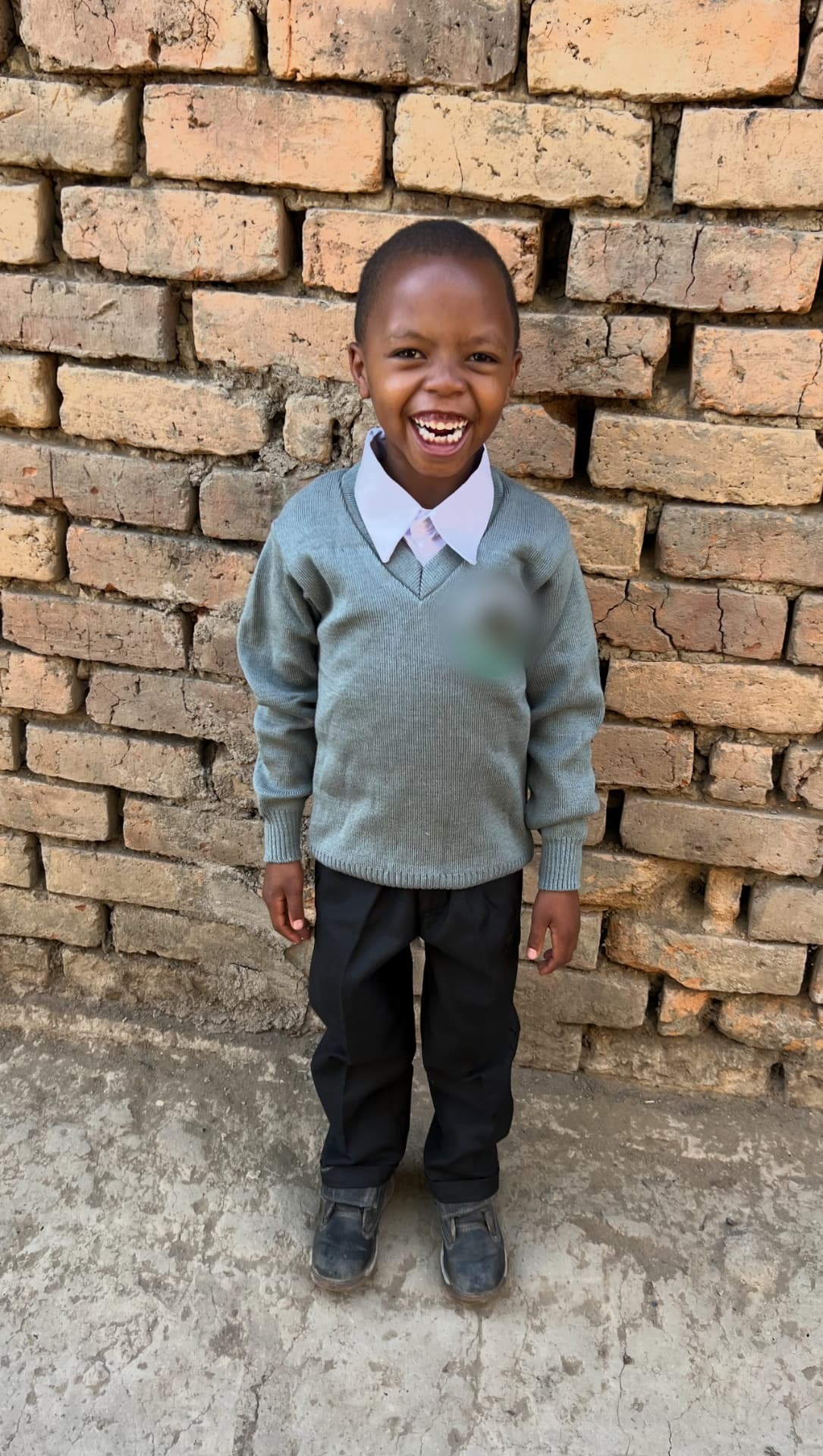 Rahim laughing in his school uniform.
